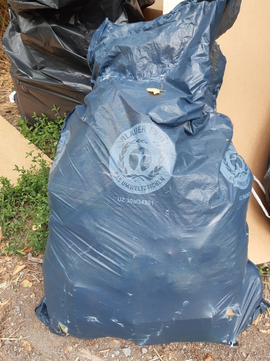 Ein blauer Müllsack gefüllt mit Abfall Ein blauer Müllsack gefüllt mit Abfall