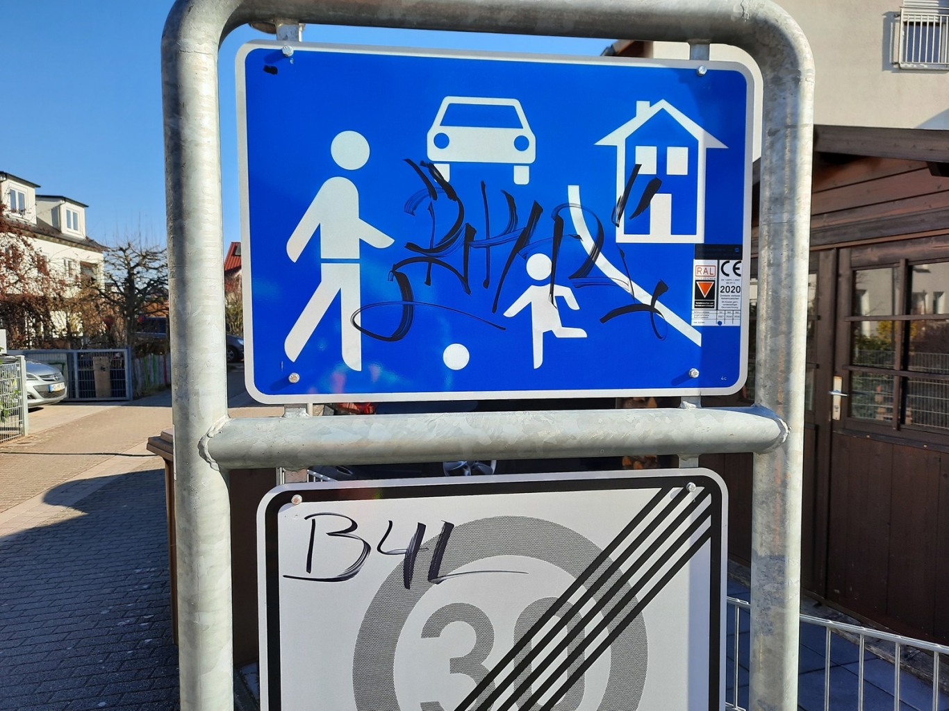 Straßenschild mit Schmiererei verunziert.