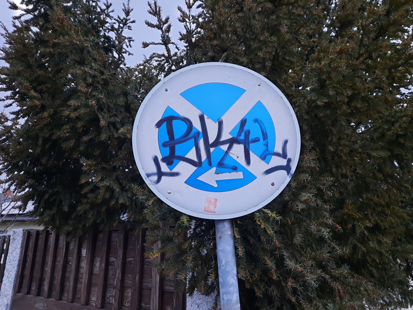 Straßenschild mit Schmiererei verunziert.