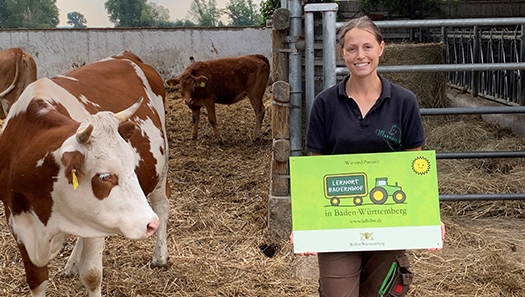 Bauernhof - Betriebsleiterin Carolin Hoffmann mit dem „Lernort Bauernhof“-Schild Bauernhof - Betriebsleiterin Carolin Hoffmann mit dem „Lernort Bauernhof“-Schild