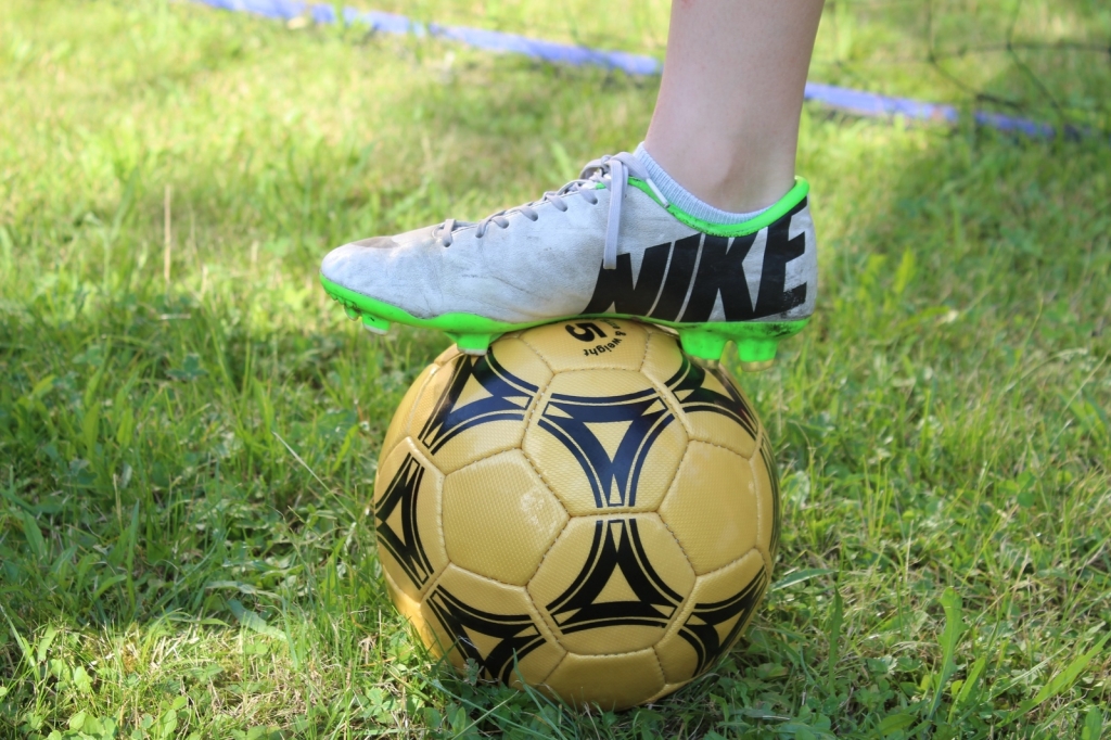 Fußball mit Fußballschuh auf grünem Rasen (Symbolbild) Fußball mit Fußballschuh auf grünem Rasen (Symbolbild)
