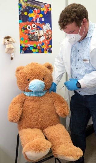 In den Impfstützpunkten Rhein-Neckar und Sinsheim starten die ersten Impfungen gegen COVID-19 von Kindern ab fünf Jahren. Dazu wurden die Impfkabinen kinderfreundlich eingerichtet und ein separater Wartebereich geschaffen. Christoph Schulze (ärztlicher Leiter Impfen) probte bereits mit einem Teddybären. (Quelle: Landratsamt Rhein-Neckar-Kreis) In den Impfstützpunkten Rhein-Neckar und Sinsheim starten die ersten Impfungen gegen COVID-19 von Kindern ab fünf Jahren. Dazu wurden die Impfkabinen kinderfreundlich eingerichtet und ein separater Wartebereich geschaffen. Christoph Schulze (ärztlicher Leiter Impfen) probte bereits mit einem Teddybären. (Quelle: Landratsamt Rhein-Neckar-Kreis)