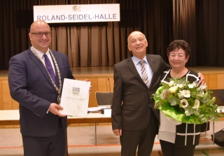 Bürgermeister Jens Geiß überreicht die Urkunde zum Ausscheiden aus dem Gemeinderat an Roland Seidel, Gisela Seidel erhält einen Blumenstrauß. Bürgermeister Jens Geiß überreicht die Urkunde zum Ausscheiden aus dem Gemeinderat an Roland Seidel, Gisela Seidel erhält einen Blumenstrauß.