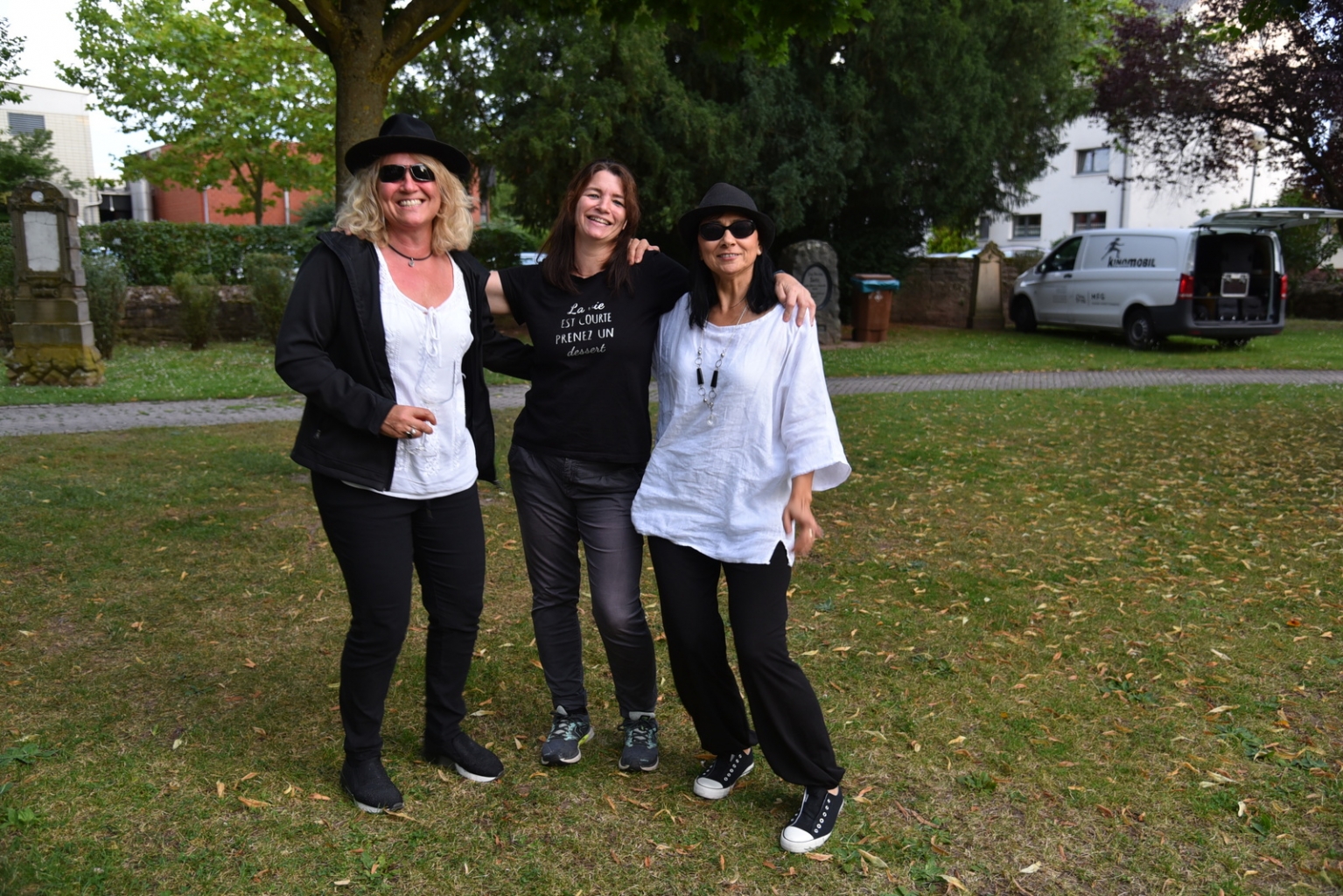 Besucherinnen sind wie die Blues Brothers in schwarz-weiß gekleidet und tragen Sonnenbrille.