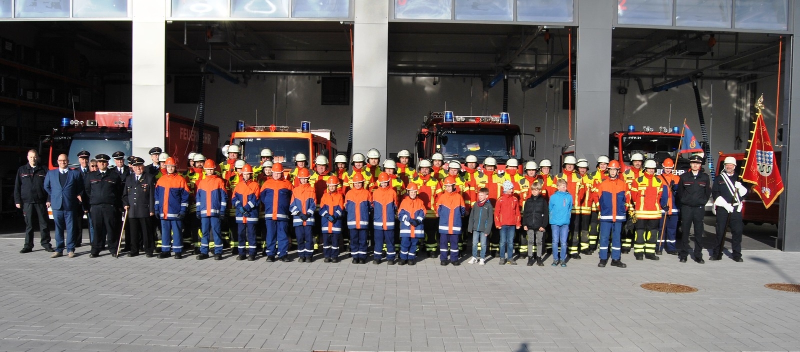 Alle Feuerwehrwagen sind ordentlich eingeparkt, alle Mitglieder der Feuerwehr stehen vor dem neuen Domizil.