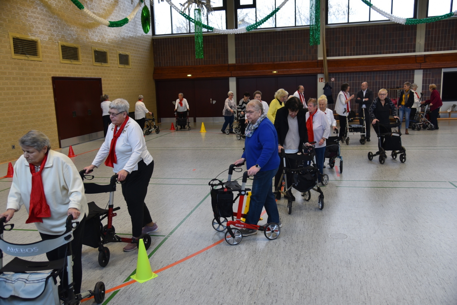 Alle Seniorinnen und Senioren üben den Parcourslauf mit dem Rollator.