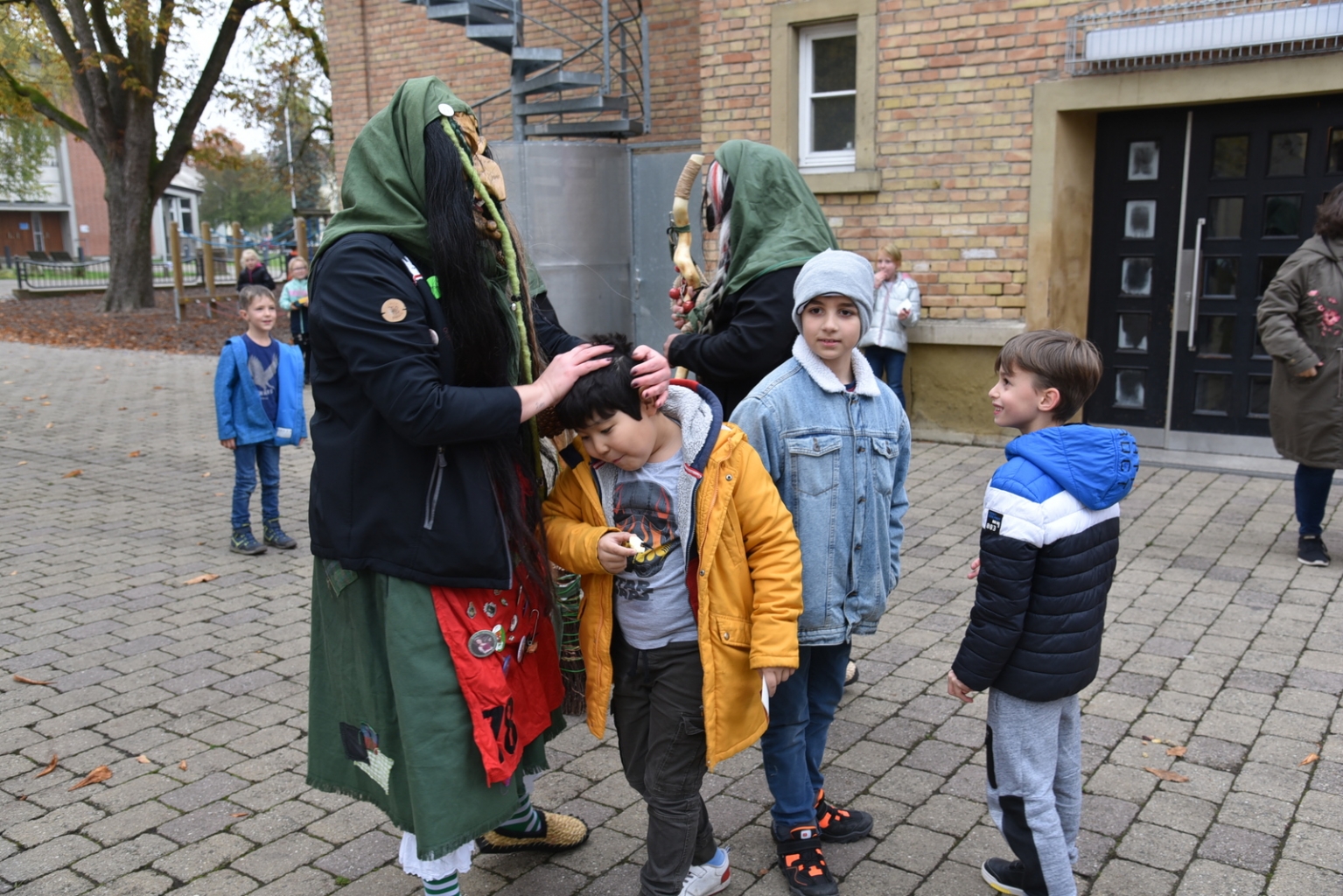 Die Buzzelhexen necken die Kinder auf dem Schulhof neben dem Rathaus.